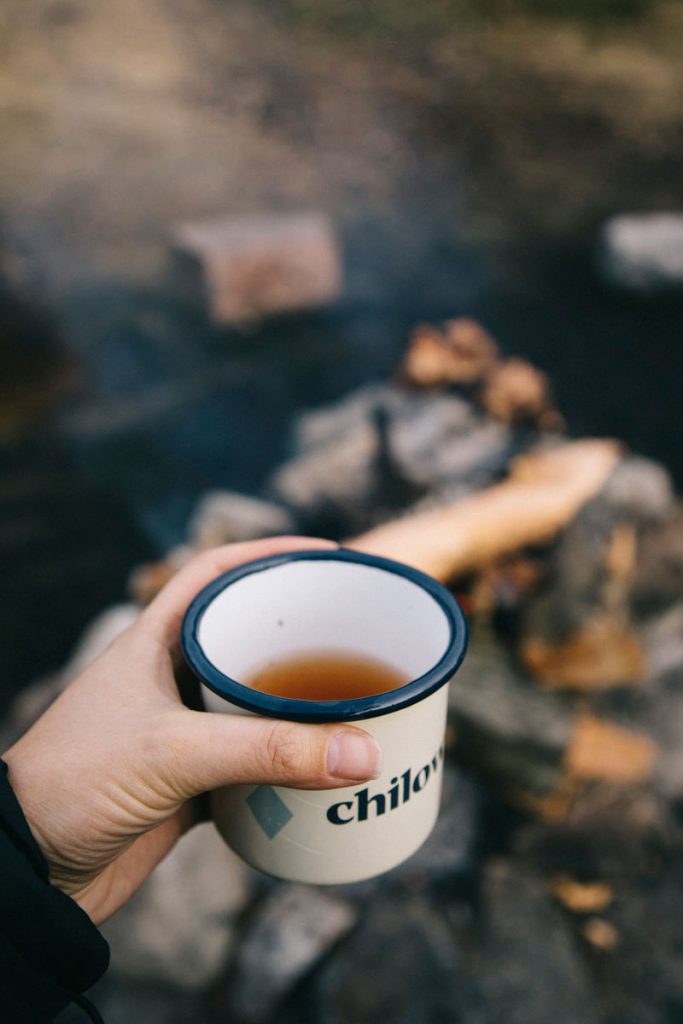 partager une tasse de thé avec d'autres randonneurs au coin du feu
