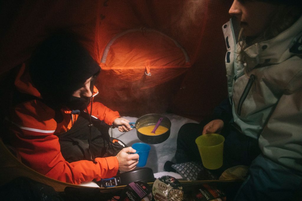 Faire à manger dans la tente lors d'un bivouac en hiver. crédit photo : Clara Ferrand - blog Wildroad